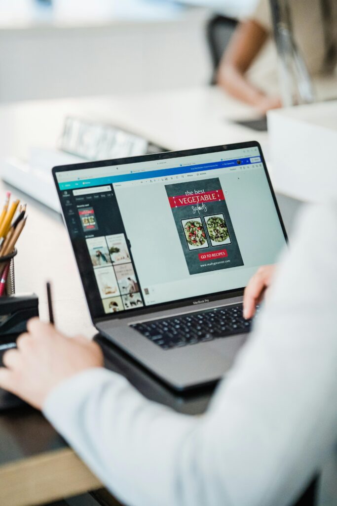 South African small business owner designing email newsletter on laptop